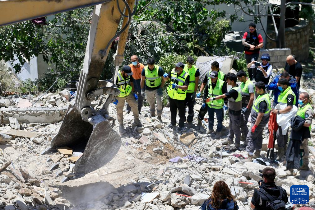 5月20日，在黎巴嫩南部提尔地区，救援人员在以色列空袭后的建筑废墟上开展搜救。新华社发（阿里·哈希绍摄）