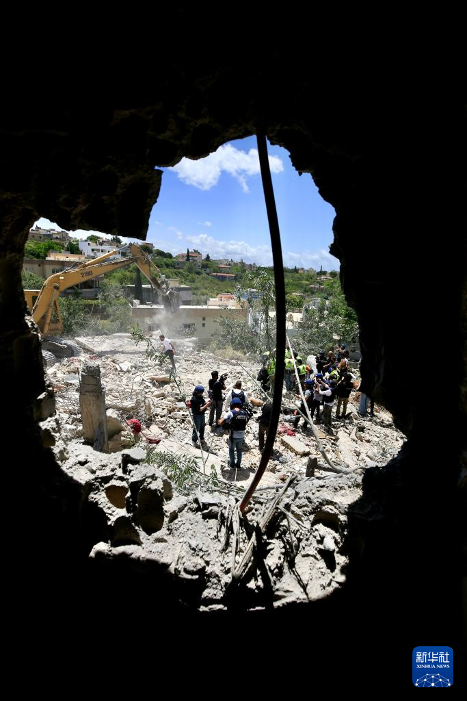 5月20日，在黎巴嫩南部提尔地区，救援人员在以色列空袭后的建筑废墟上开展搜救。新华社发（阿里·哈希绍摄）
