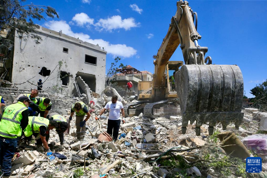 5月20日，在黎巴嫩南部提尔地区，救援人员在以色列空袭后的建筑废墟上开展搜救。新华社发（阿里·哈希绍摄）