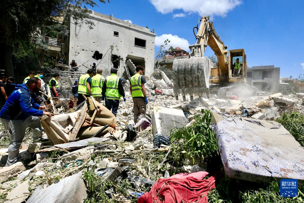 5月20日，在黎巴嫩南部提尔地区，救援人员在以色列空袭后的建筑废墟上开展搜救。新华社发（阿里·哈希绍摄）