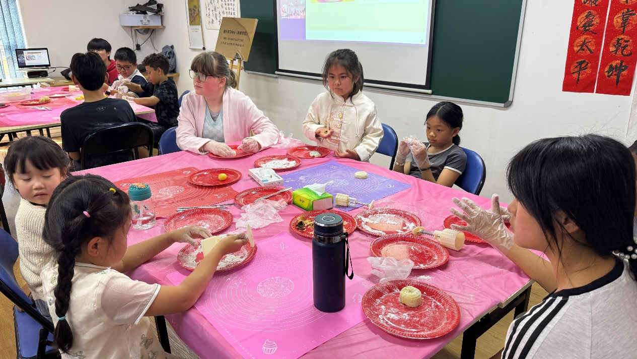 图为华裔儿童与当地儿童共同制作冰皮月饼。以上图片均为南非开普敦华星艺术团供图