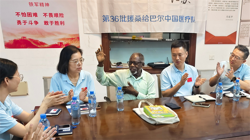哈吉老院长和队员们一起“唱红歌”。中国援桑医疗队供图