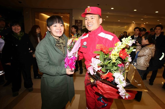 2011年3月21日,在北京首都国际机场,中国国际救援队队员陈庆开(前右)的妻子张虹霞(前左)前来接机。
图片:新华社发(摄影:李方宇)