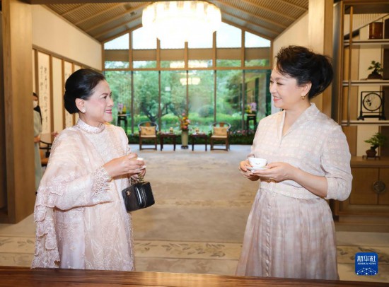  7月27日下午，国家主席习近平夫人彭丽媛在四川成都会见陪同印度尼西亚总统佐科来华出席第31届世界大学生夏季运动会开幕式并访华的总统夫人伊莉亚娜。这是彭丽媛邀请伊莉亚娜观看茶艺表演，并同伊莉亚娜亲切茶叙。新华社记者 丁林 摄