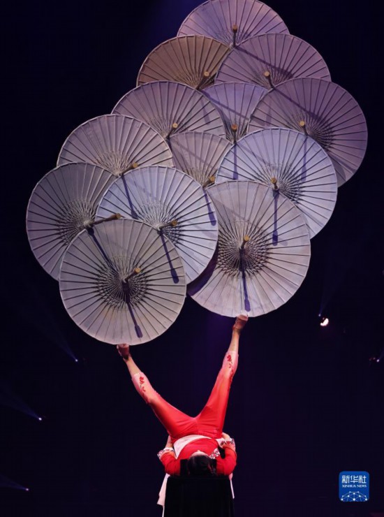 12月8日，演员在法国巴黎举行的中国杂技“奇妙之夜”演出上表演《蹬伞》。新华社记者 高静 摄
