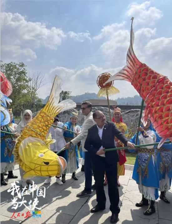 5月19日，参加“机遇中国·品牌重庆”驻华使节重庆行活动的驻华使节在大足体验鲤鱼灯舞。（海外网 谢明 摄）