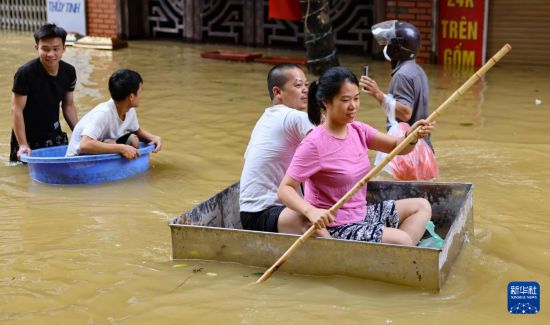 9月12日，在越南首都河内市嘉林县，受灾民众在洪水中前行。新华社/越通社