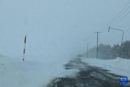 这是2月4日在日本札幌郊外拍摄的被积雪部分覆盖的道路。新华社记者 李子越 摄