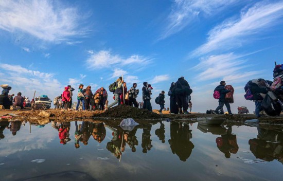 1月28日，在加沙地带中部努赛赖特难民营附近，流离失所的民众行进在返回加沙地带北部的路途上。新华社发（里泽克·阿卜杜勒贾瓦德摄）