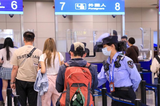 　　2025年5月3日，无锡边检站工作人员在无锡硕放机场边检入境现场引导外籍游客。新华社发（朱吉鹏摄）