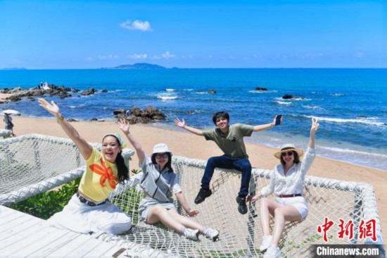 6月8日，华侨大学“海外新声代”工作室成员在三亚天涯海角游览区合影。 (海南省国际文化交流中心 供图)
