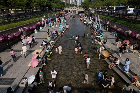 6月14日，人们在韩国首尔的清溪川戏水。新华社发（全休相摄）