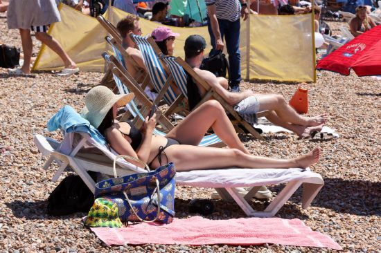 　　2025年7月12日，人们在英国南部布赖顿的海滩休闲。英国气象局11日发布公告说，英格兰大部分地区都已达到热浪标准，高温健康警报已升级为琥珀色。这是英国今年夏季遭遇的第三波热浪。新华社发