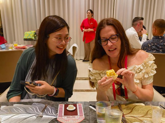 9月14日，入境游客对一款小吃很感兴趣，展开讨论。新华社记者 陈爱平 摄