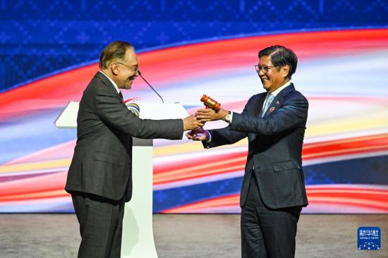 10月28日，在马来西亚吉隆坡举行的第47届东盟峰会及系列会议闭幕式上，马来西亚总理安瓦尔（左）将轮值主席国木槌移交给2026年东盟轮值主席国菲律宾总统马科斯。新华社记者 程一恒 摄