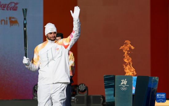 12月6日，意大利本土第一棒火炬手、意大利游泳运动员帕尔特里涅里在火炬传递前向观众致意。新华社记者 李京 摄