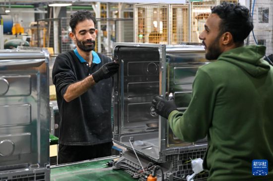 1月19日，在埃及苏赫奈泉的中埃·泰达苏伊士经贸合作区，埃及员工在美的埃及厨房和热水器有限公司洗碗机生产车间组装洗碗机。新华社记者 辛梦晨 摄