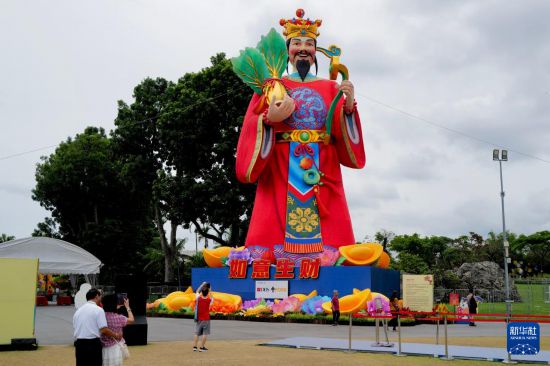 2月20日，在新加坡滨海湾花园，游客拍摄财神爷彩灯。新华社记者 刘颍 摄