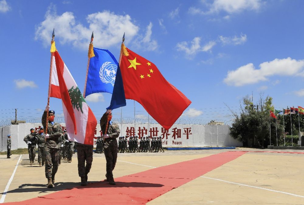 ↑在黎巴嫩南部辛尼亚村的中国维和队伍营区，中国维和队伍官兵在受勋后通过不雅礼台（2022年7月1日摄）。新华社记者 刘宗亚 摄