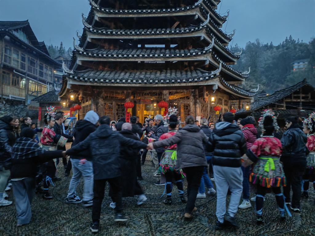 法國青年與當地村民牽手跳舞。新華社記者 羅羽 攝