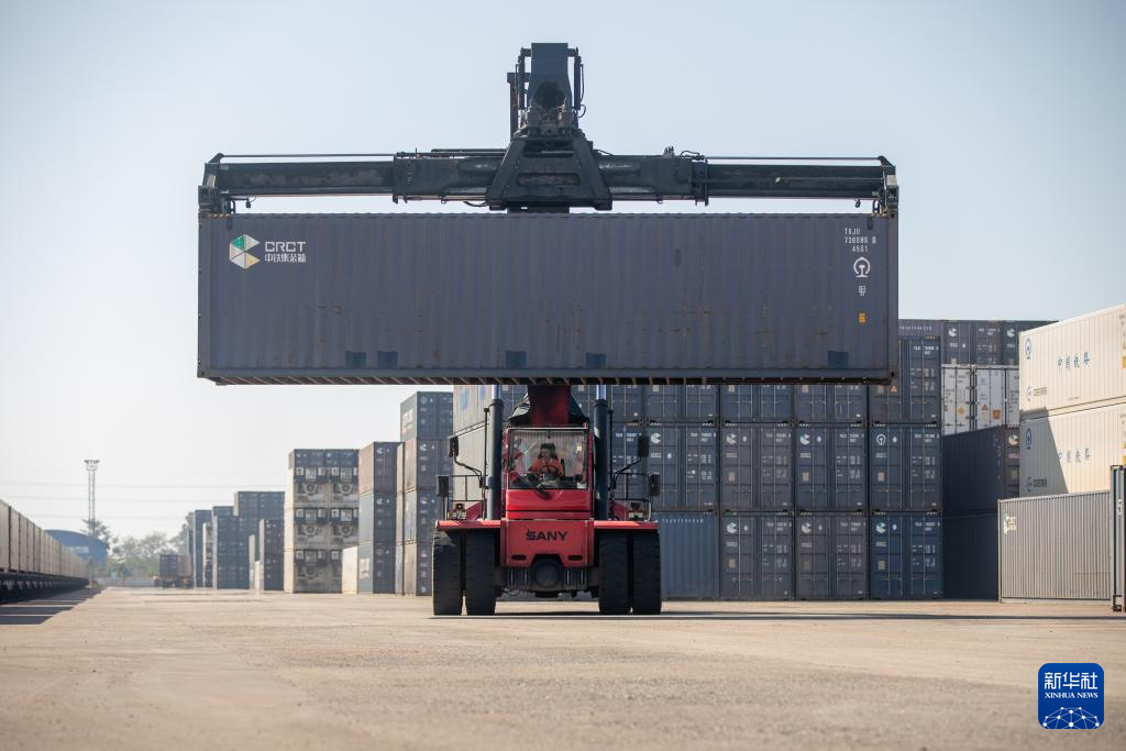 11月29日,在老挝首都万象中老铁路万象南站,工作人员进行集装箱吊装作业。新华社发(凯乔摄)