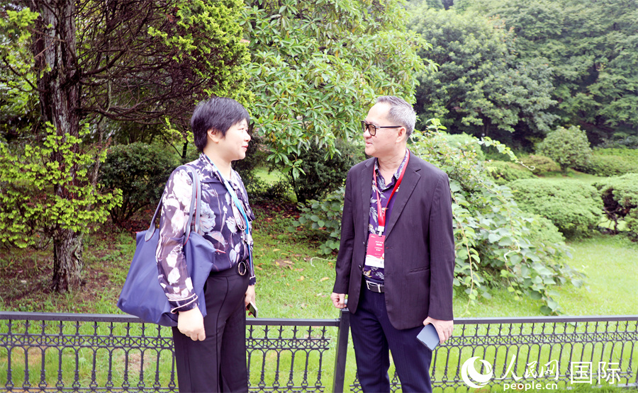 柬埔寨记者俱乐部主席布伊格（右）同复旦大学自贸区综合研究院院长助理卢华（左）在庐山植物园内交流。人民网记者 赵益普摄
