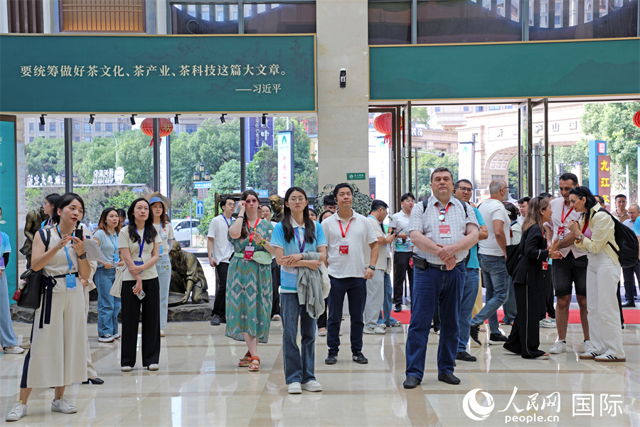 外媒记者在九江茶市展厅内听取讲解。人民网记者 赵益普摄