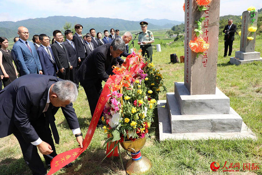 当地时间7月25日，中国驻朝鲜使馆祭扫球场郡中国人民志愿军烈士陵园。图为王亚军大使带领中方一行向纪念碑敬献花篮。人民网记者 刘融摄