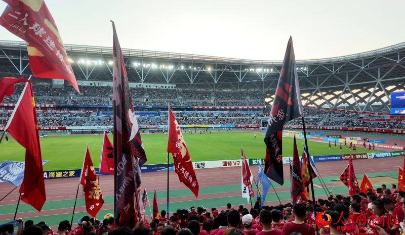 球迷赛前为球队摇旗加油。人民网 周锦佳摄