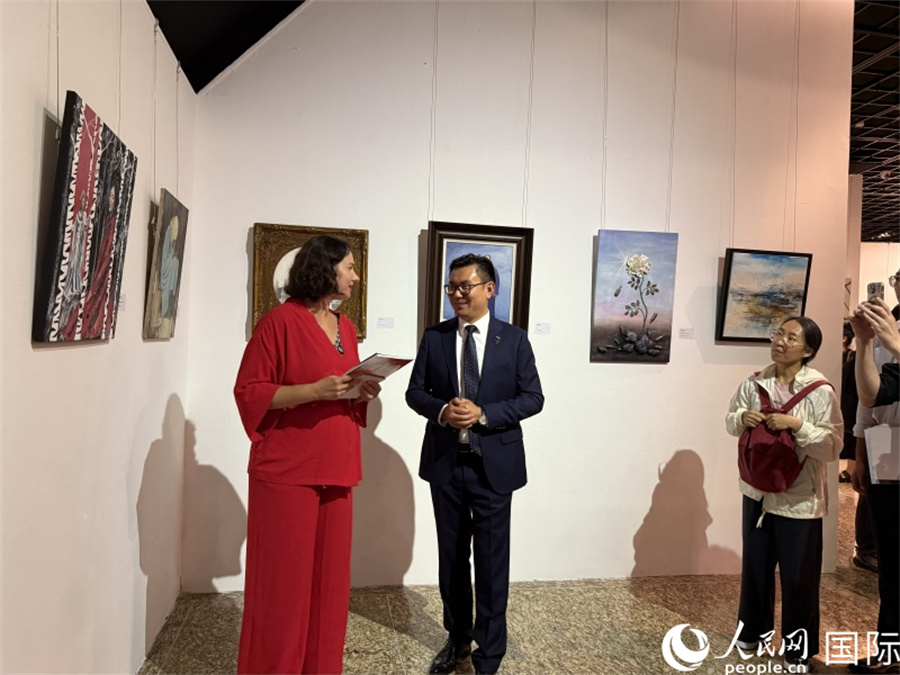 俄罗斯艺术家伊丽莎白·多罗菲耶娃向现场嘉宾介绍自己的作品。人民网记者 杨倩摄