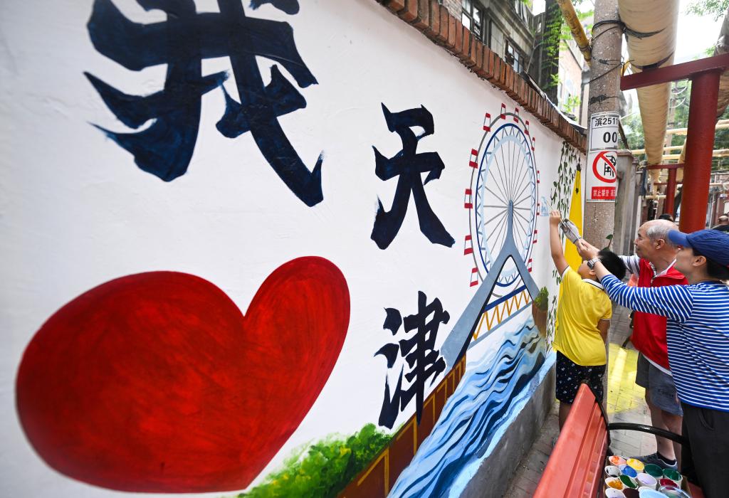 8月15日，在天津市和平区劝业场街道兆丰路社区，志愿者和社区居民对一处胡同的老旧墙体进行彩绘美化。新华社记者 赵子硕 摄