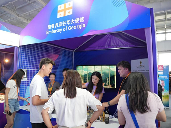 格鲁吉亚展台前，参展商正在向现场观众推介相关产品。赵天翊摄