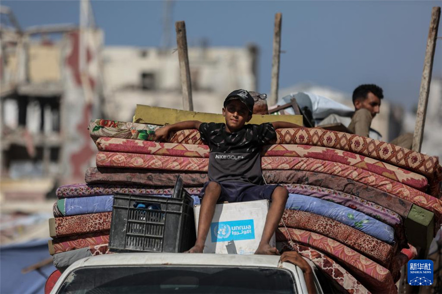 9月18日，在加沙城以西的沿海公路上，儿童与家人一起运载着生活用品，汇入人潮向南撤离。新华社发（里泽克·阿卜杜勒贾瓦德摄）