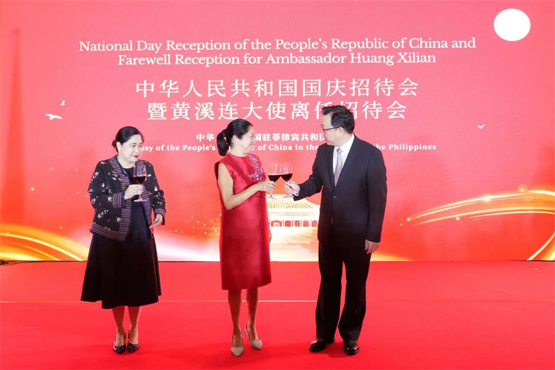 菲律宾总统夫人丽莎·马科斯、菲外交部代理外长德维加（左一）与黄溪连大使举杯庆祝中华人民共和国国庆。中国驻菲律宾使馆供图