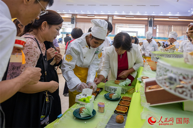 当地观众在联欢会现场品尝月饼。人民网记者 谢佳君摄