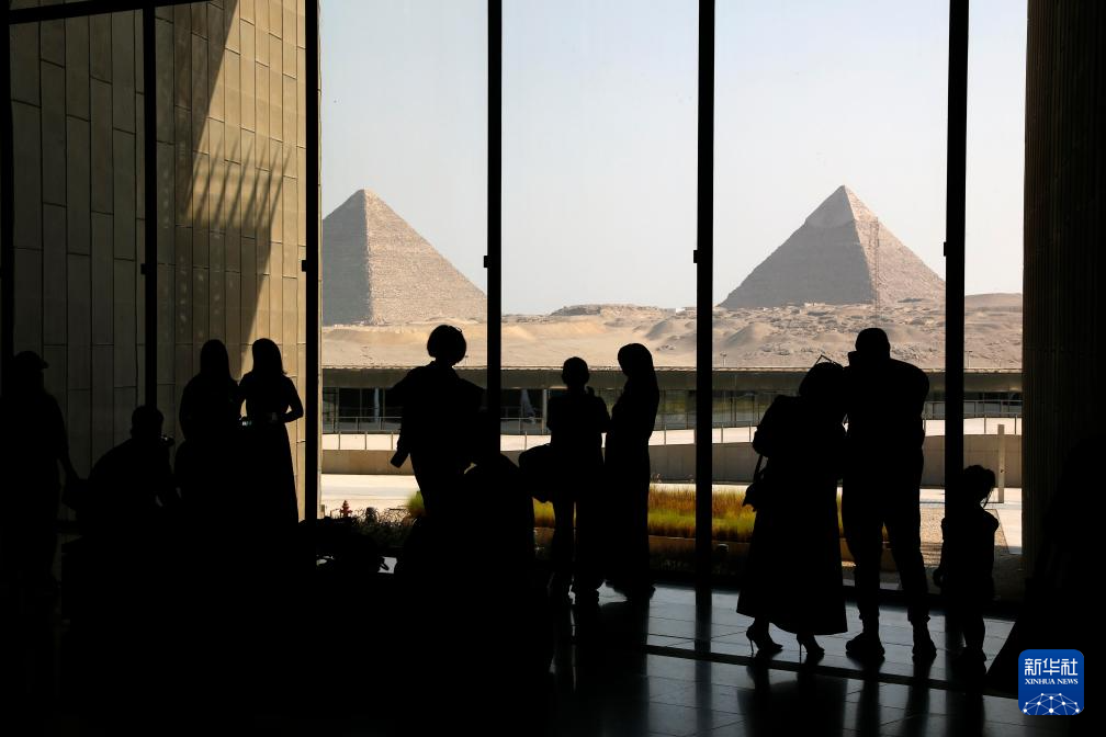 10月14日，游客在位于埃及吉萨省的大埃及博物馆远观吉萨金字塔群。新华社发（艾哈迈德·戈马摄）