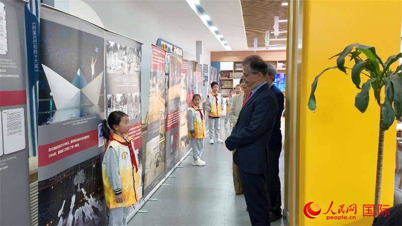 希腊驻华大使卡尔佩里斯认真聆听主题展览小讲解员的讲解。人民网 殷韬摄