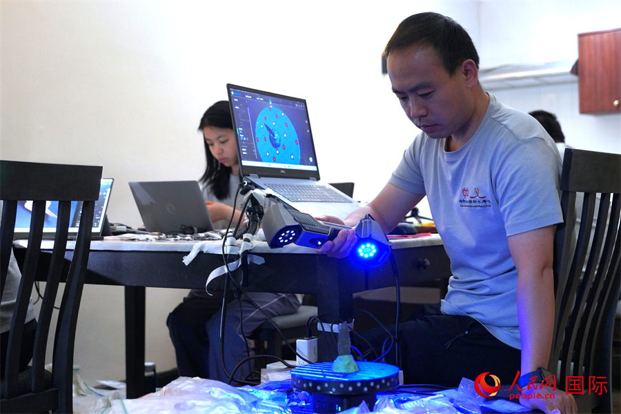 中方队员娄文台使用三维扫描仪获取石器三维模型。人民网记者 黄炜鑫摄