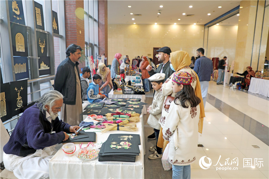博览会上，参观者在手工艺品展位前驻足。人民网记者 赵益普