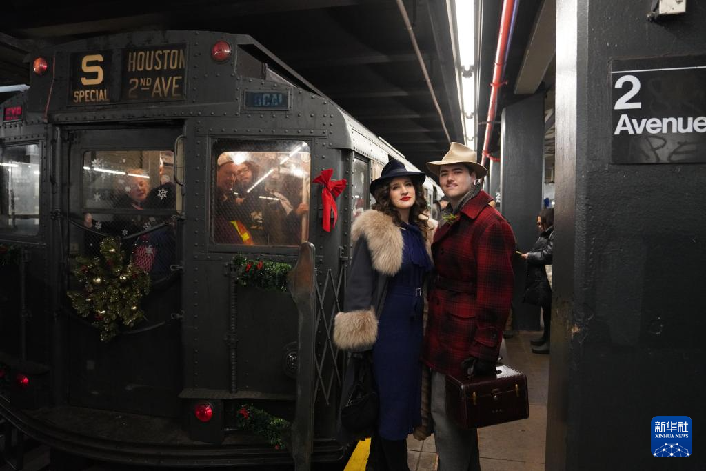 12月14日，在美国纽约，人们身着怀旧服饰准备乘坐“怀旧地铁”。新华社记者 张凤国 摄