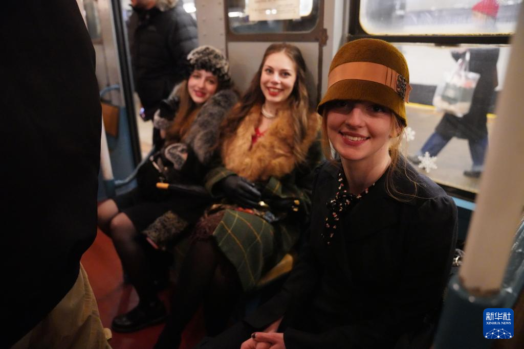 12月14日，在美国纽约，人们身着怀旧服饰乘坐“怀旧地铁”。新华社记者 张凤国 摄