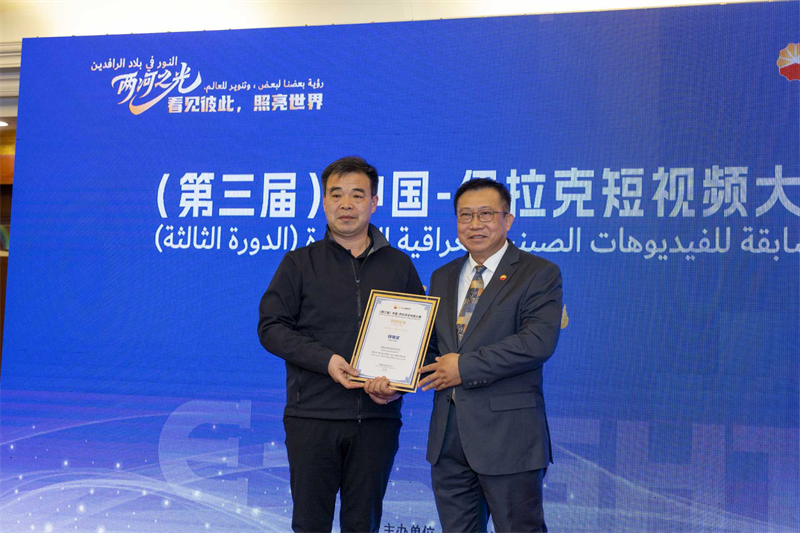 伊拉克中资企业商会会长、中国石油中东公司总经理陈欣荣为特等奖作品颁奖。中阿卫视供图