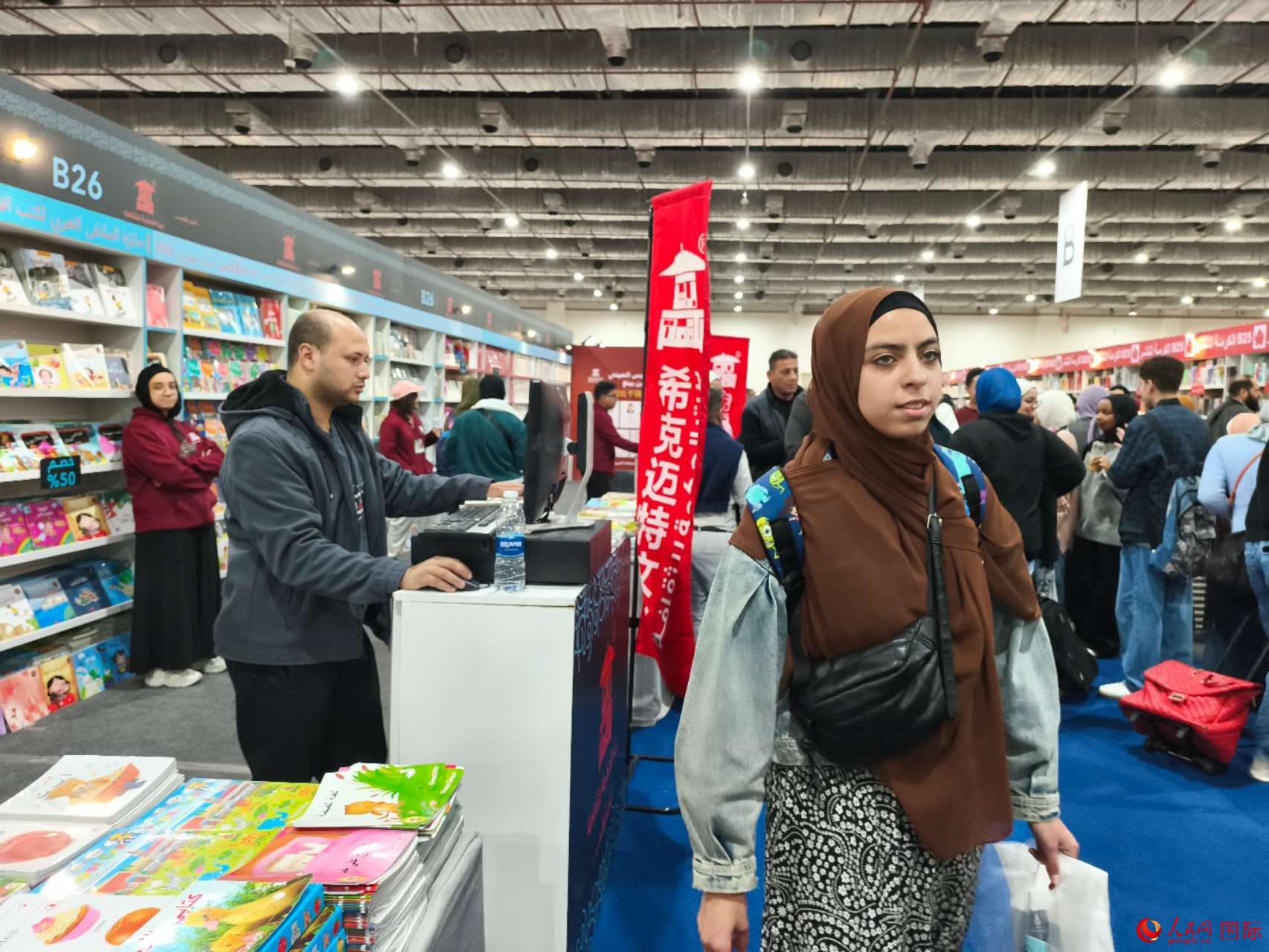 一位读者从经营中国图书的希克迈特文化展台前走过。人民网记者 黄培昭摄