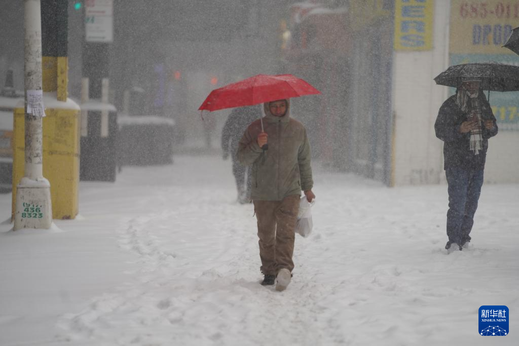 1月25日，在美国纽约，人们雪中出行。新华社记者 张凤国 摄
