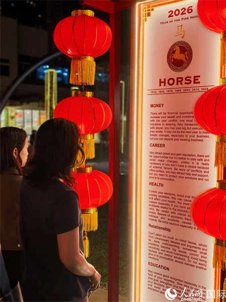 在菲律宾最繁华的博尼法乔环球中心商业区步行街，菲律宾民众在介绍十二生肖等春节习俗的展牌前驻足观看。人民网记者樊帆  摄