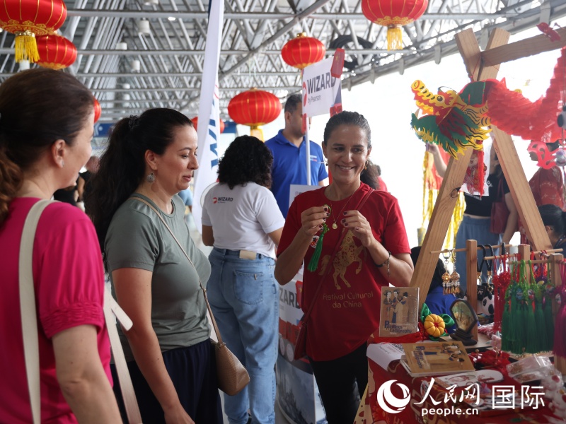 活动参与者在文化展台前购买装饰品。人民网记者 时元皓摄