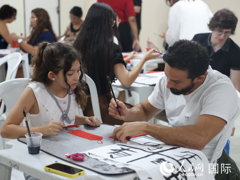 活动参与者在中国文化体验课程中体验中国书法。人民网记者 时元皓摄