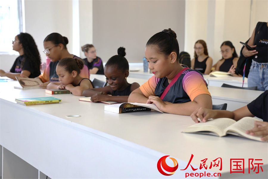 4月2日是国际儿童图书日，巴西里约热内卢北部的曼吉尼奥斯社区芭蕾舞学校开展了一场别具特色的阅读活动，其中中文阅读成为一大亮点。图为学生们在明亮的教室中安静品读儿童图书。人民网实习生 侯天泽摄