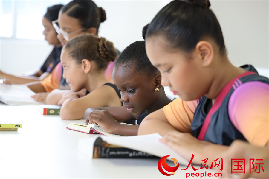 4月2日是国际儿童图书日，巴西里约热内卢北部的曼吉尼奥斯社区芭蕾舞学校开展了一场别具特色的阅读活动，其中中文阅读成为一大亮点。图为孩子们正伏案沉浸式阅读儿童图书。人民网实习生 侯天泽摄