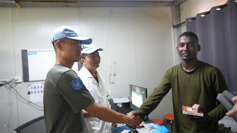 中国第六批赴阿卜耶伊维和直升机分队军医对孟加拉国官兵进行中医诊疗。黄浩摄
